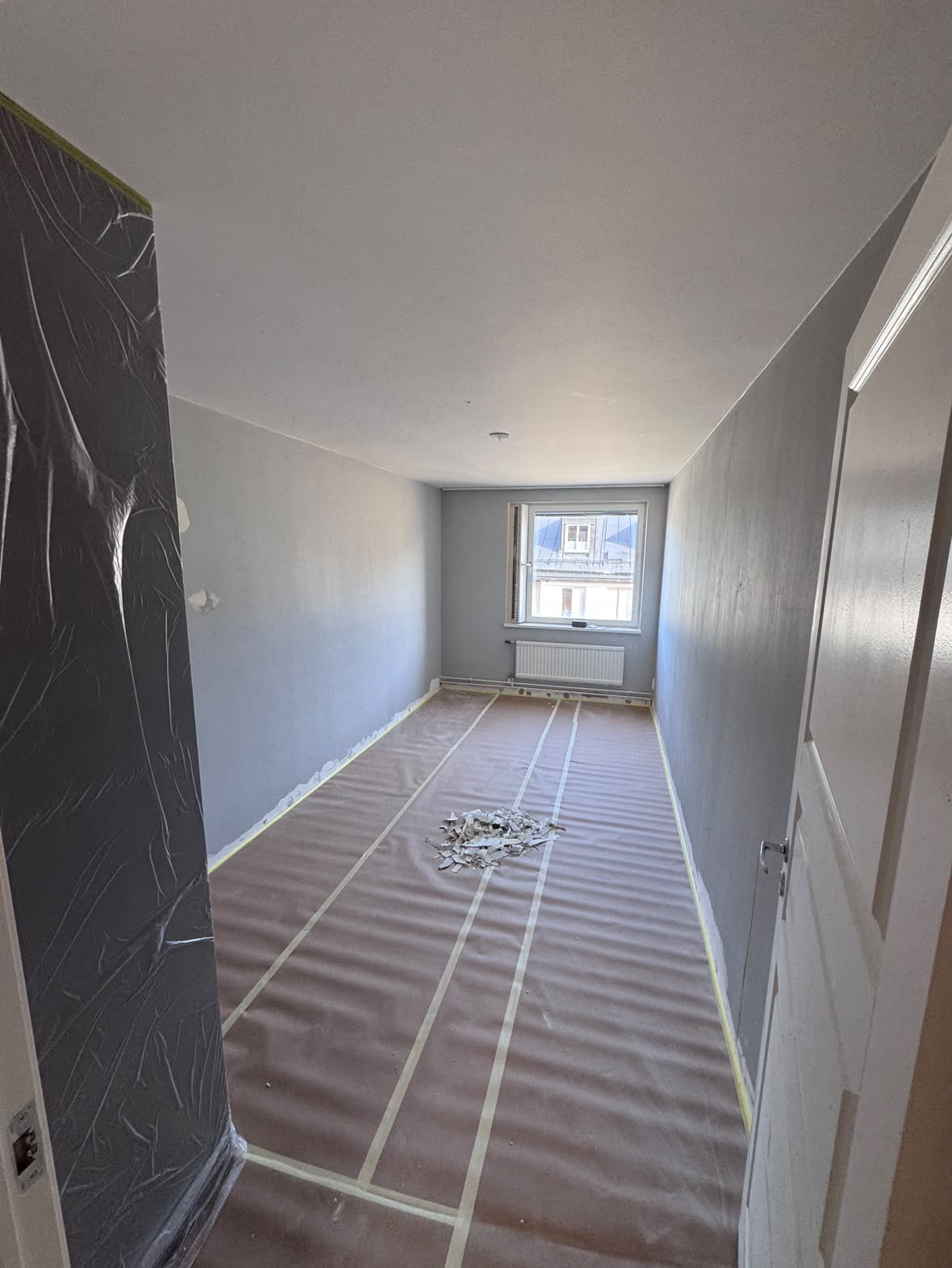 Rum under renovering med skyddat golv, före målning